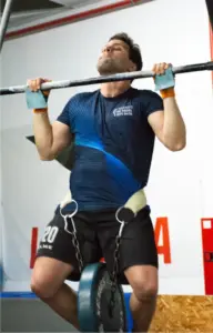 ¿Tengo que hacer RX? 2 Qué significa RX en CrossFit: atleta haciendo dominadas con lastre en CrossFit La Forja Sevilla