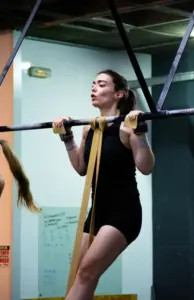 ¿Tengo que hacer RX? 3 Escalar el WOD: atleta haciendo dominadas asistidas con goma en CrossFit La Forja Sevilla